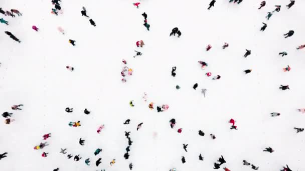 Kışın açık hava buz pateni pistinde paten kayan pek çok insan üzerinde hava aracı görüntüsü. — Stok video