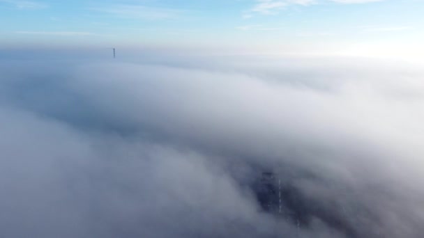 Повітряний дрон дивиться політ над туманом, що покриває місто. Мальовничий вид з повітря, що рухається туманність — стокове відео