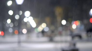 Şehir manzaralı ışıklar, yağan kar, gece caddesi, arabaların farları.