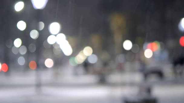 City view lichten, vallende sneeuw, nacht straat, bokeh vlekken van koplampen van auto 's — Stockvideo