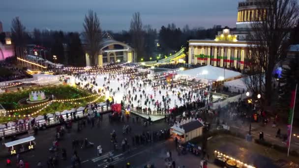 Paisagem urbana muito bonita com muitas pessoas patinando em uma pista de gelo ao ar livre — Vídeo de Stock