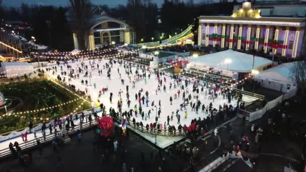 Paisaje urbano muy bonito con mucha gente patinando en una pista de hielo al aire libre — Vídeos de Stock