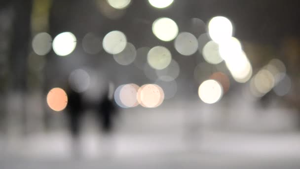 City view lichten, vallende sneeuw, nacht straat, bokeh vlekken van koplampen van auto 's — Stockvideo