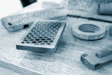 Toz endüstriyel 3D yazıcıya basılmış farklı gri nesneler.