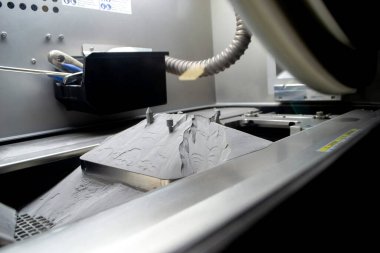 Metal 3D yazıcıda basılı nesnelerle kaplı yüzey, metal tozuyla kaplı.