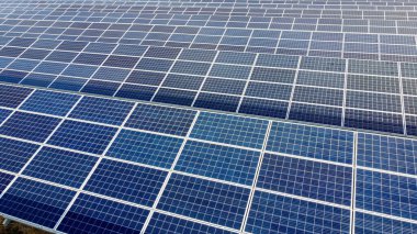 Güneşli bir günde güneş panelleri üzerinde yakın çekim yapan hava aracı görüntüsü. Fotovoltaik