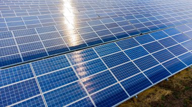 Güneşli bir günde güneş panelleri üzerinde yakın çekim yapan hava aracı görüntüsü. Fotovoltaik