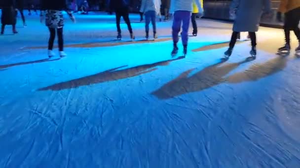 Люди катаються на ковзанах з барвистим світлом під відкритим небом взимку — стокове відео