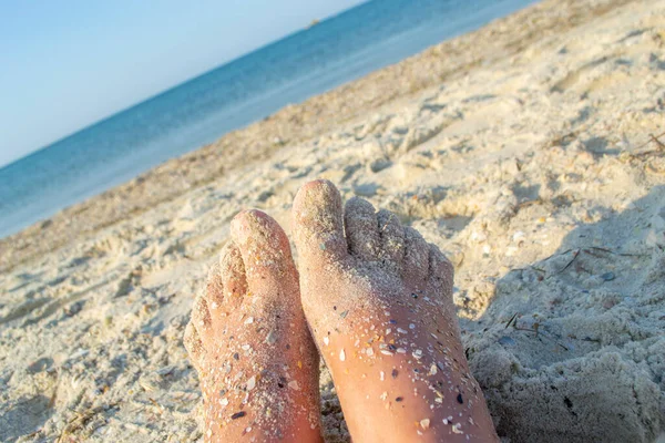 Två fot kaukasiska kvinna nedsmutsad i sand med skal sten på sandigt hav — Stockfoto