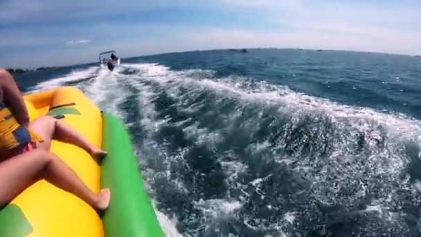 Folk rider på vatten uppblåsbar attraktion med motorbåt Banana på havet — Stockvideo