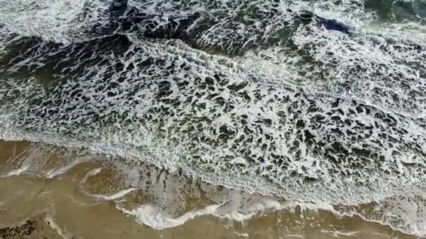 Морські хвилі з білою піною зверху. Красиві морські хвилі на морському піщаному узбережжі — стокове відео