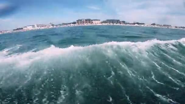 La gente que monta en la atracción inflable del agua con el barco a motor plátano en el mar — Vídeo de stock
