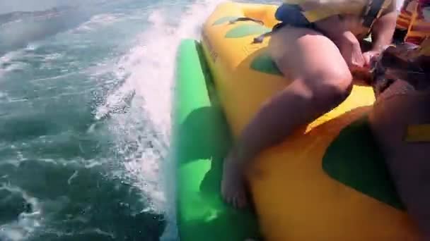 Pessoas andando na água atração inflável com barco a motor Banana no mar — Vídeo de Stock