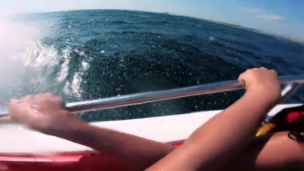 Моторная лодка прыгает по морским волнам в солнечный день. Голубая морская вода, белые брызги — стоковое видео