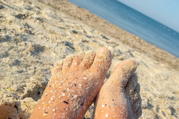 Dois pés descalços de mulher caucasiana suja na areia com casca de rocha no mar arenoso — Fotografia de Stock