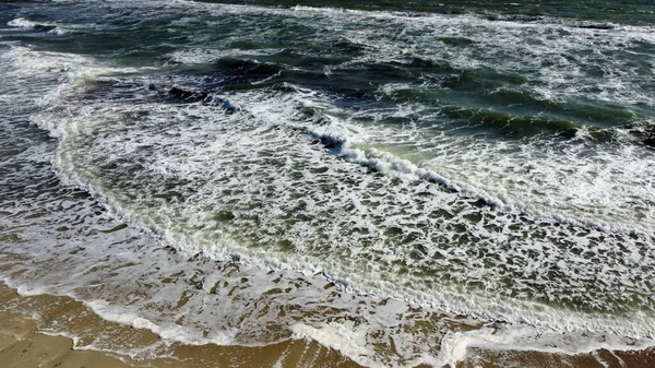 Політ повітряного дрона над красивими морськими хвилями на піщаному пляжі з білою піною — стокове фото