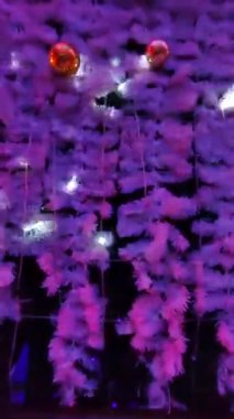 Noel süsü, duvarda mor renkli Noel topları, yanıp sönen beyaz ışıklar