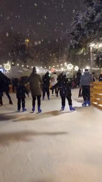 オープンエアのアイススケートリンクでスケートをする人も多いです。垂直ビデオ — ストック動画