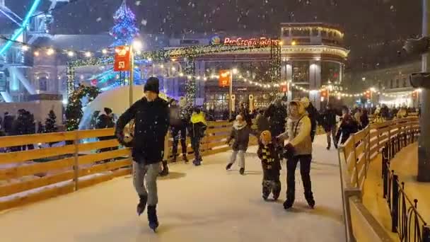 Veel mensen schaatsen op openlucht schaatsbaan sneeuwval — Stockvideo