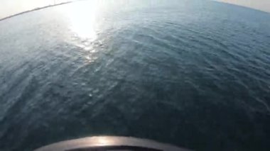 Deniz manzarası, deniz dalgaları, motorlu teknenin pruvasından yansıyan güneş ışığı.