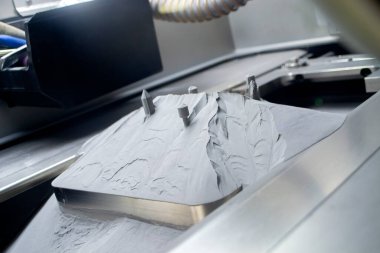 Metal 3D yazıcıda basılı nesnelerle kaplı yüzey, metal tozuyla kaplı.