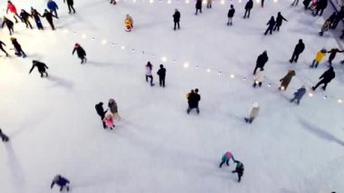 Bir kış günü açık havada buz pateni pistinde kayan insanların en iyi görüntüsü..