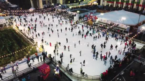 Sehr schöne urbane Landschaft mit vielen Menschen, die auf einer Open-Air-Eisbahn Schlittschuh laufen — Stockvideo