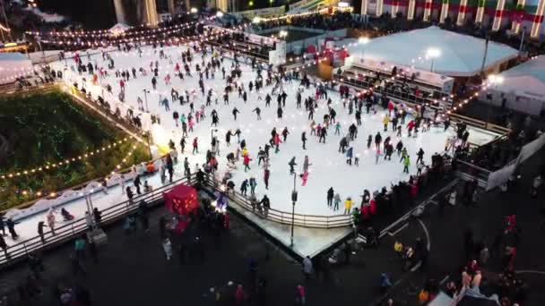 オープンエアのアイスリンクで多くの人がスケートしている非常に美しい都市の風景 — ストック動画