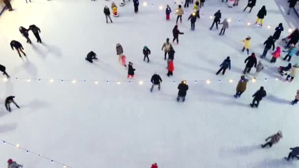 Aerial Drone View Sok ember korcsolyázik egy szabadtéri jégpályán télen. — Stock videók