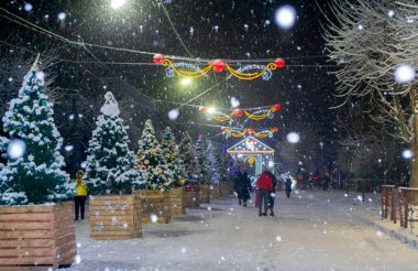 Karlı şehir caddesi Noel ağaçları ve aydınlatma dekorasyonuyla