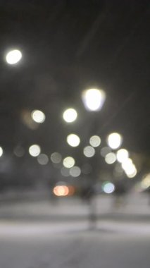 Şehir manzaralı ışıklar, yağan kar, gece caddesi, arabaların farları.