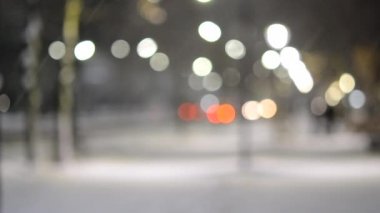 Şehir manzaralı ışıklar, yağan kar, gece caddesi, arabaların farları.