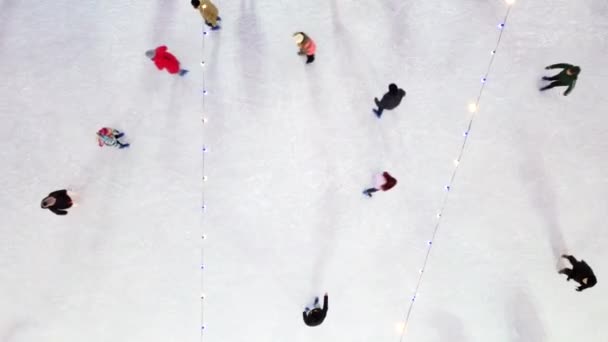 Mädchen skaten, fahren aufeinander zu und umarmen sich. Schlittschuhlaufen auf Freiluft-Eisbahn — Stockvideo