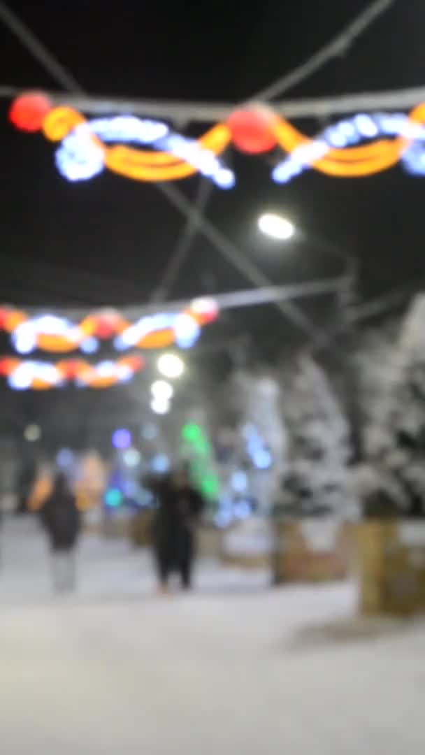 背景がぼやけている。冬の夜の降雪時の街の通り. — ストック動画