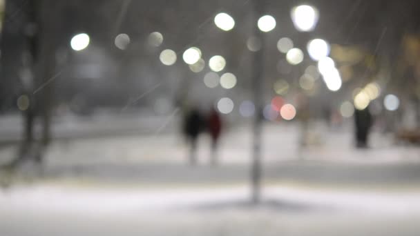 City view lichten, vallende sneeuw, nacht straat, bokeh vlekken van koplampen van auto 's — Stockvideo