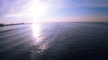 Deniz manzarası, deniz dalgaları, motorlu teknenin pruvasından yansıyan güneş ışığı..