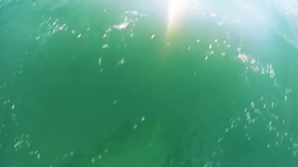 Vue de la surface de l'eau de la mer avec de la mousse blanche et le reflet du bateau — Video