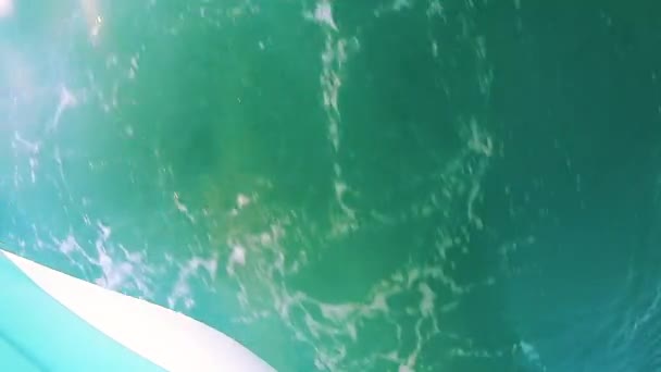 Widok na powierzchnię wody morza z białą pianką i odbiciem łodzi — Wideo stockowe