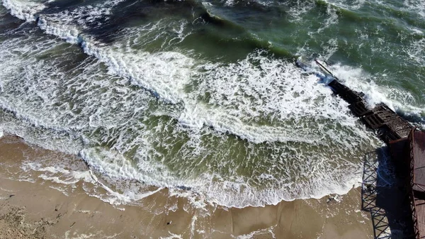 Vue aérienne d'un drone survolant des vagues qui roulent sur la rive sablonneuse. Vue du dessus — Photo