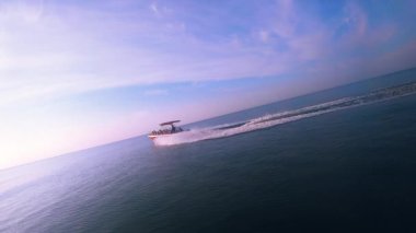 Güneşli bir günde insanlarla dolu bir motorlu tekne denizde yüzüyor. Deniz Burnu.