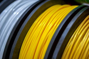 3D yazıcıya yakın çekimde yazdırmak için çok renkli plastik iplikler