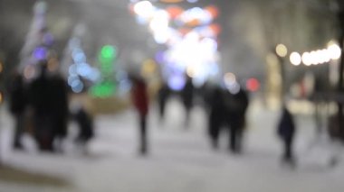 Arka plan bulanık. Kış gecesi kar yağarken şehir caddesi. Işıklandırma