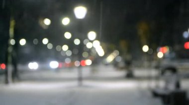 Şehir manzaralı ışıklar, yağan kar, gece caddesi, arabaların farları.
