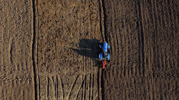 Le conducteur du tracteur sur les charrues du tracteur atterrit. Aérien. Agriculteur dans le sol de labour tracteur — Photo