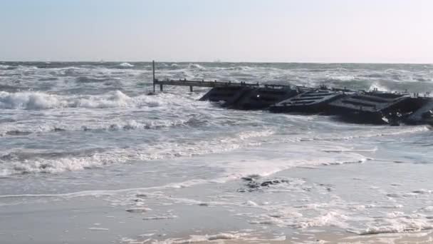 Silne fale morskie rozbijają się na kamieniu z betonową płytą falochron stare molo — Wideo stockowe
