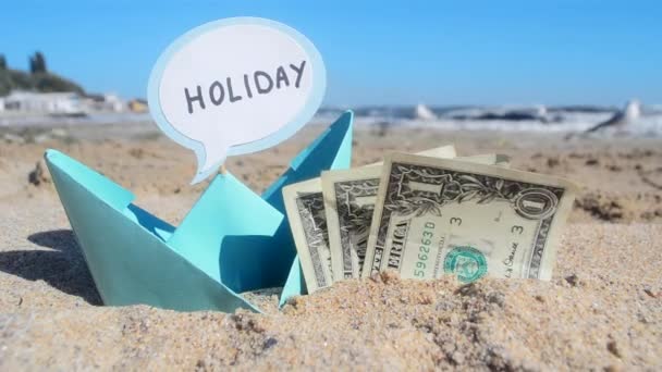 Pequeño barco de papel azul, billetes de tres dólares y burbuja en la arena — Vídeo de stock