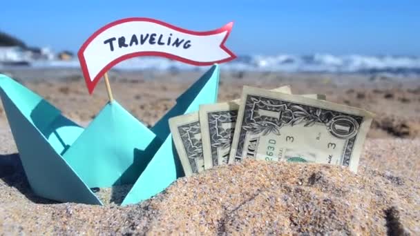 Pequeño barco de papel azul, billetes de tres dólares y burbuja en la arena — Vídeo de stock