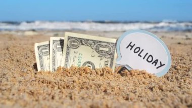 Kağıt banknotlar bir dolar ve küçük bir sopa ile kağıt konuşma baloncuğu ile kelime tatili