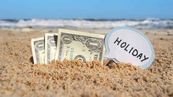 Papierscheine Ein-Dollar-Schein und kleiner Stick mit Papiersprechblase mit Schriftzug Urlaub — Stockvideo