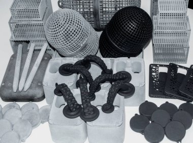 Birçok model 3D yazıcıda basıldı. Gri ve siyah nesneler 3D yazıcı.